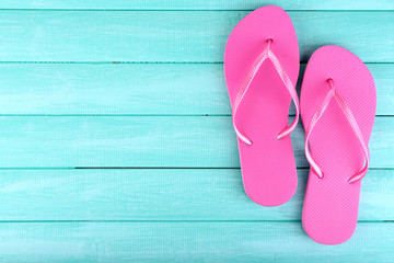 Bright flip-flops on color wooden background