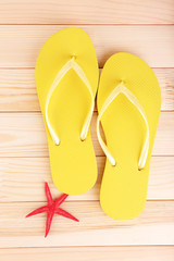 Bright flip-flops on wooden background