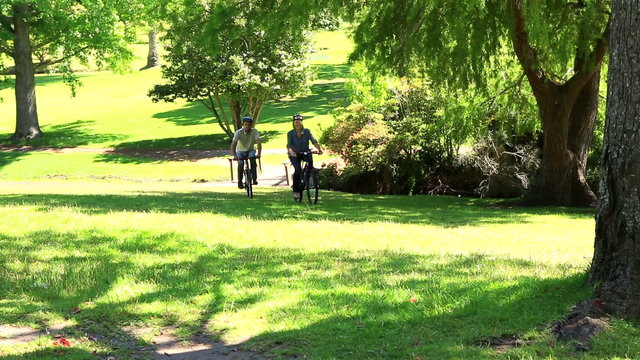 Happy couple going for a bike ride in the park