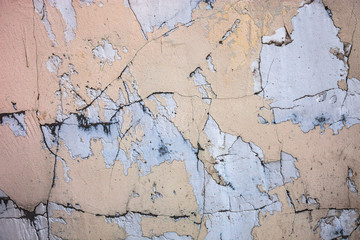 Cracked concrete surface with the remains of sandy-tan paint