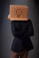 Young man gesturing with a cardboard box on his head with light