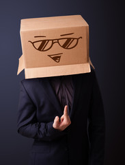 Young man gesturing with a cardboard box on his head with smiley