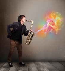 Attractive musician playing on saxophone with colorful abstract