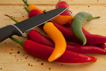 Chilis auf Holzbrett mit Messer