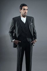 Mafia fashion man wearing grey striped suit. Black hair and brow