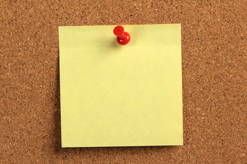 yellow sticky note on a cork board