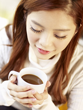 young woman holding cup of coffee high angle view