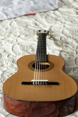 Spanish guitar lying on the bed