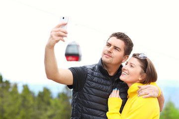 Young couple taking pictures in mountains