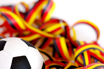 ein Fußball und Luftschlangen in schwarz, rot, gelb