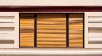 Closed window with brown wooden shutters