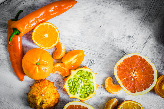 Orange fruits and vegetables on rustic background