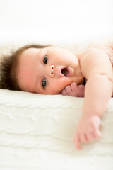 small baby girl lying on white bed