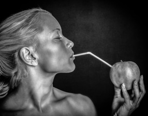 Monochrome photo of a woman drinking apple juice