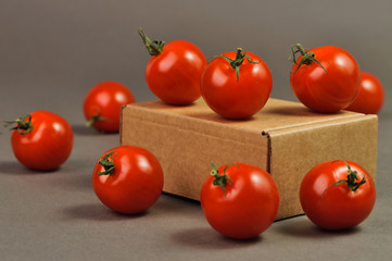 small tomatoes and brown box on a grey background