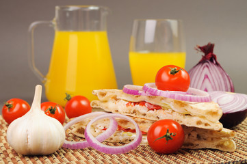 sandwich with tomatoes garlic and onion near juice