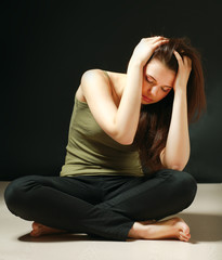 Depressed woman sitting on floor with eyes closed
