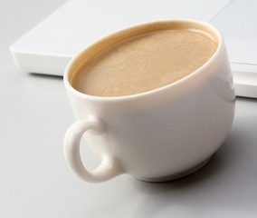 cup of coffee near the laptop