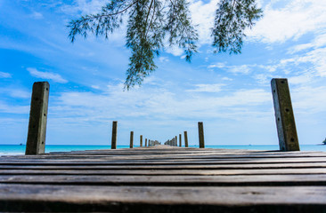Naklejka premium Wooden pier with blue sea and sky background