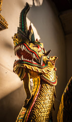 Thailands golden dragon head by old temple.