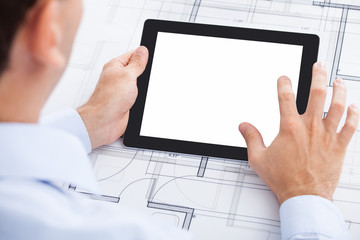 Businessman Holding Blank Digital Tablet Over Blueprint