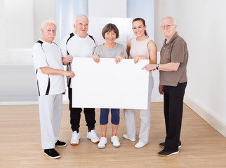 People Holding Blank Billboard At Gym