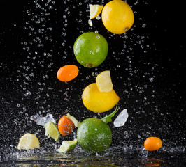 Fototapeta na wymiar Citrus fruit in water splash on black background