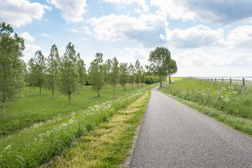 Fototapeta na wymiar Curved country road along a Dutch dike