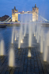 Tower Bridge and a fountain at dusk.