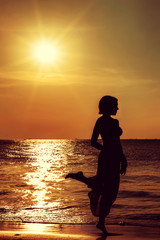 Fototapeta premium silhouette of a girl against the sunset sea