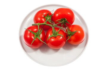 Fresh tomatoes on plate. Isolated on white background