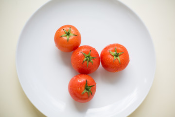 Four tomatoes on a plate