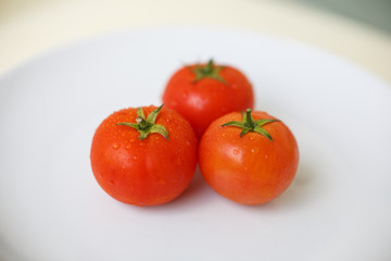 Ripe tomatos on a white plate