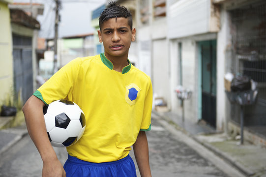 Young Brazilian Football Player Holding Soccer Ball on Street