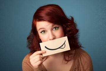 Pretty young girl holding white card with smile drawing