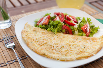 Omelette with vegetable salad on an wood table