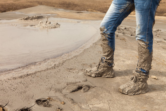 Muddy And Dirty Hiking Boots And Blue Jeans