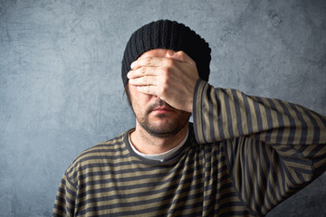 Man covering eyes