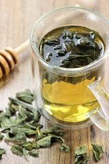 Salbeitee im Glas auf Holztisch