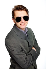 Young businessman in suit with sunglasses on isolated background