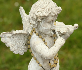 statue of little angel playing violin