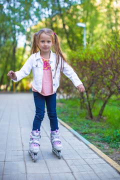 Adorable little girl on roller skates in the park