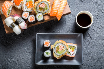 Sushi served with soy sauce on black stone