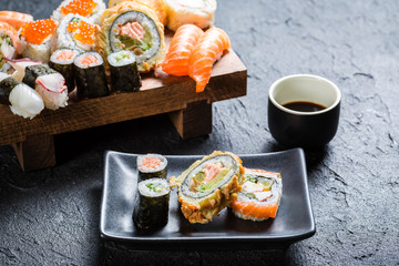 Sushi with soy sauce on black stone