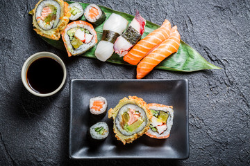 Closeup of sushi with soy sauce on black rock