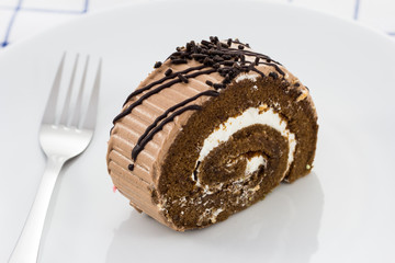 Roll chocolate cake on white plate