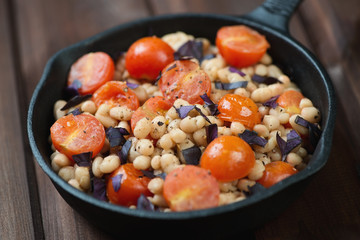 Roasted white beans with cherry tomatoes in a frying pan