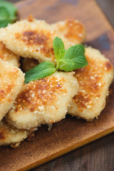Sesame chicken nuggets with mint leaves, vertical shot