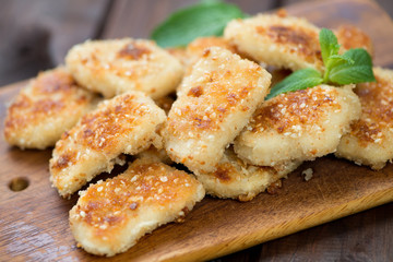 Wooden cutting board with sesame chicken nuggets