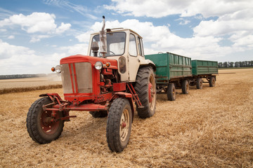 old tractor in field, against a cloudy sky